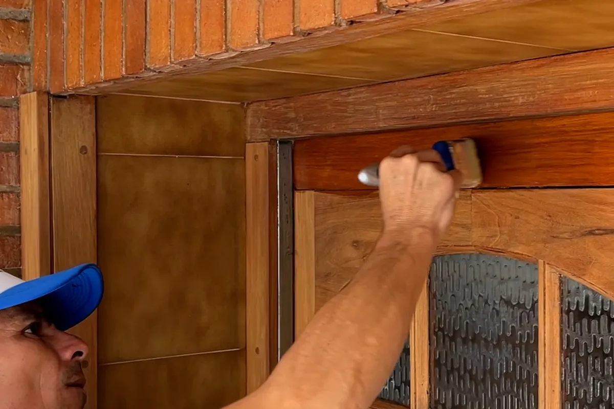 Detalle de un pintor de Pintura Express aplicando esmalte sobre carpintería de madera