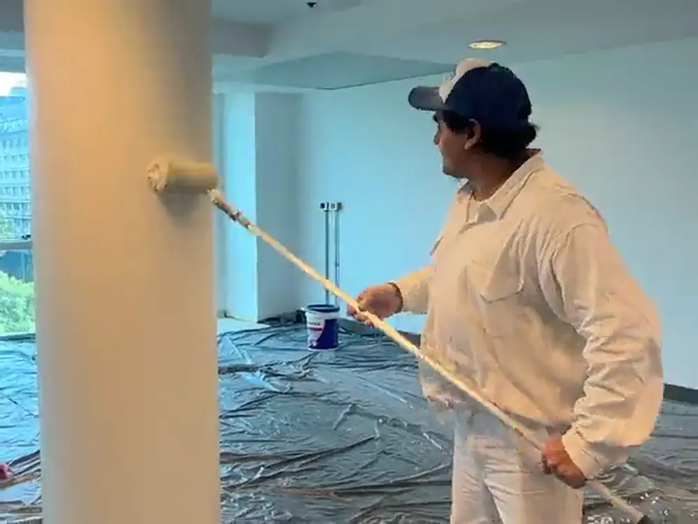 Pintor de Pintura Express pintando una columna en una planta de oficinas del centro de Buenos Aires